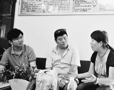 本报记者张洋（左一）在社区指导站采访。资料照片