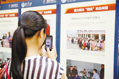  重庆渝北区市民正在用手机拍摄图片展内容。重庆渝北区委宣传部供图