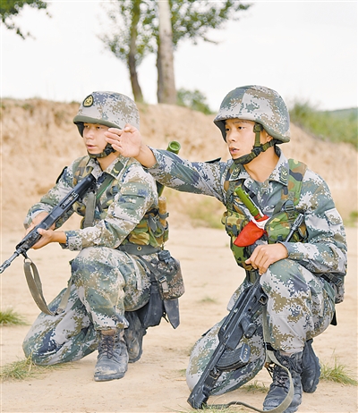 8月下旬，今年已经被确定为优秀士兵保送入学对象的某部班长赵振龙（右）仍坚守岗位，在训练场组织班战术演练。周　胜摄　