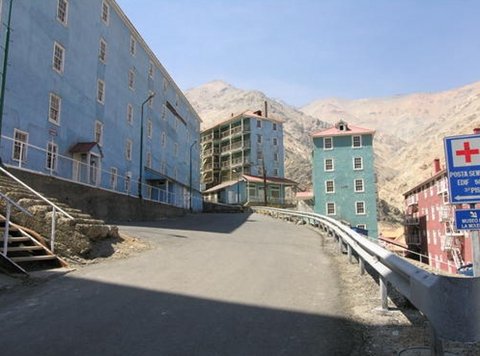 沿街建筑是由原木搭建的，通常漆成鲜艳的绿色、黄色、红色和蓝色
