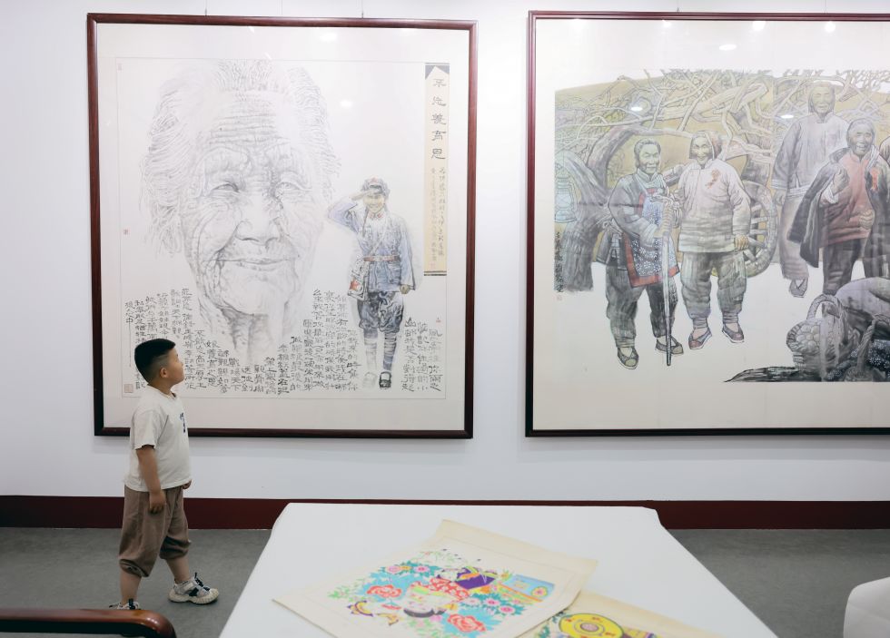 2025年5月24日，一名小朋友在莒县沂蒙画派研究院观看画作。新华社发（兰红光摄）