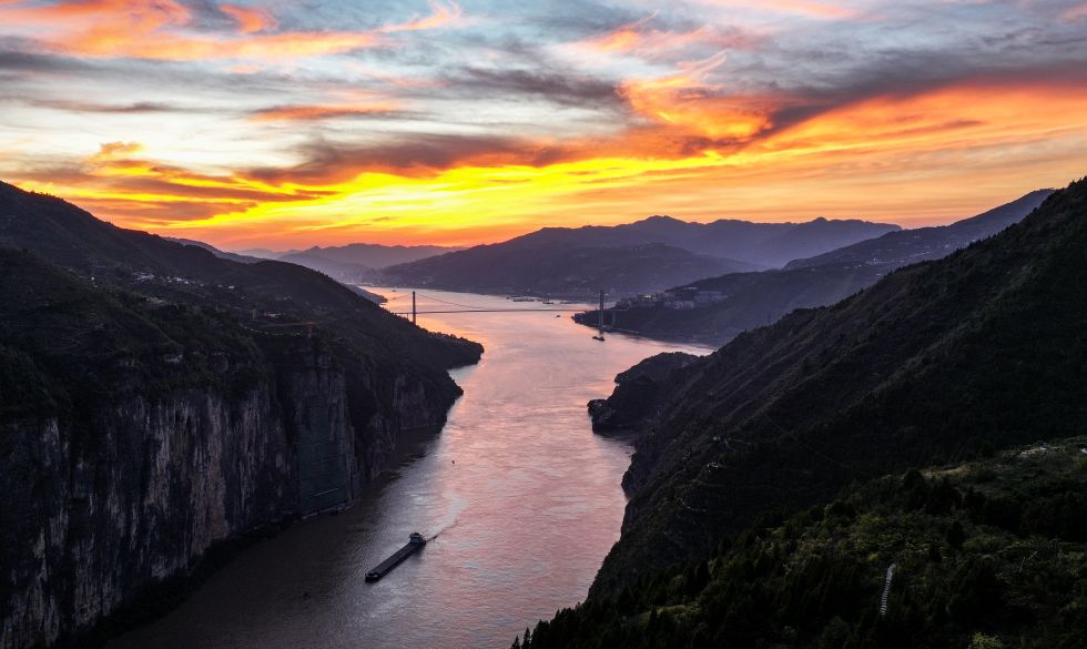 2025年10月5日,在长江三峡瞿塘峡峡口附近,夕阳映红天空和江面(无人机照片)。 新华社记者 陈晔华 摄
