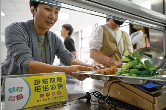 2025年6月10日,职工在安徽省合肥市庐阳区亳州路街道食堂就餐。食堂通 过张贴宣传海报等方式,引导职工厉行节约、杜绝浪费。