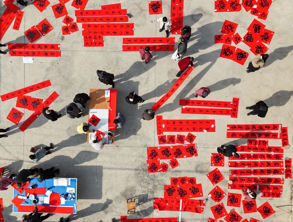 2026年 2月5日,在河南省焦作市温县黄庄镇后崔庄村,书法家为村民书写福字和春联(无人机照片)。 新华社发(黄福兴摄)