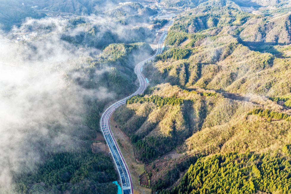 这是2025年12月13日在石柱县冷水镇拍摄的穿行于山间的高速公路(无人机照片)。 新华社记者 唐奕 摄
