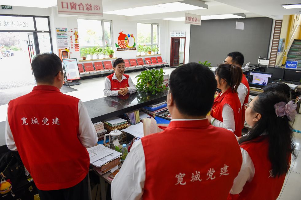 2026年6月9日,在吉林省长春市宽城区团山街道长山花园社区,吴亚琴(左二)向社区工作人员传授工作方法。 新华社记者 张楠 摄